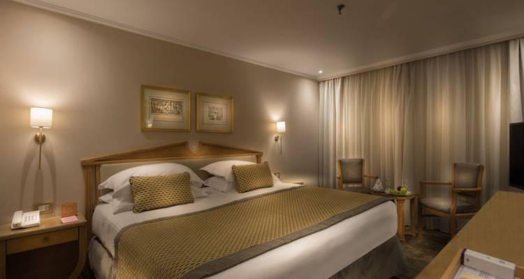 Hotelzimmer mit warmer Beleuchtung und bequemem Bett.