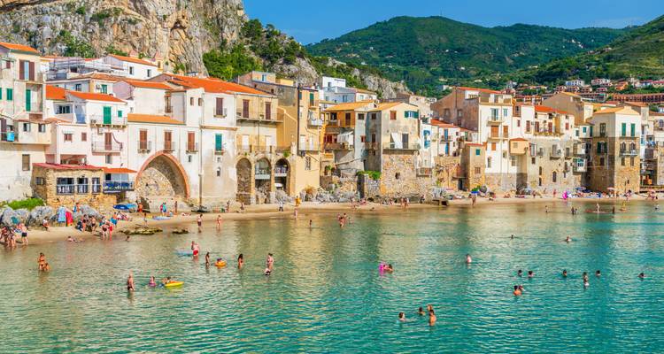 A coastal town with vibrant buildings and a beach.