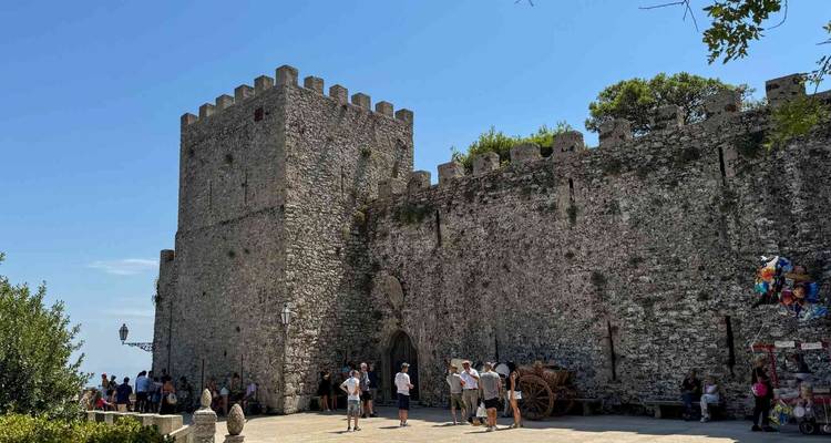 Visitors exploring an ancient castle with stone walls.