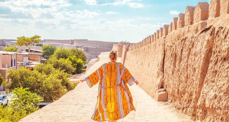 Une personne marchant le long d'un mur historique avec des vues étendues.