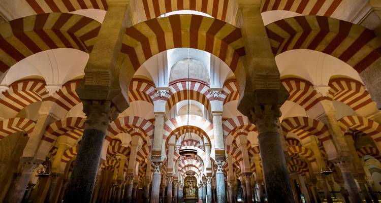 Vue intérieure d'une mosquée historique avec des arcs.