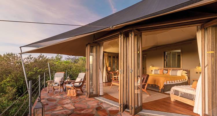 Luxuriöse Zeltunterkunft mit Innenansicht und Außensitzplatz.