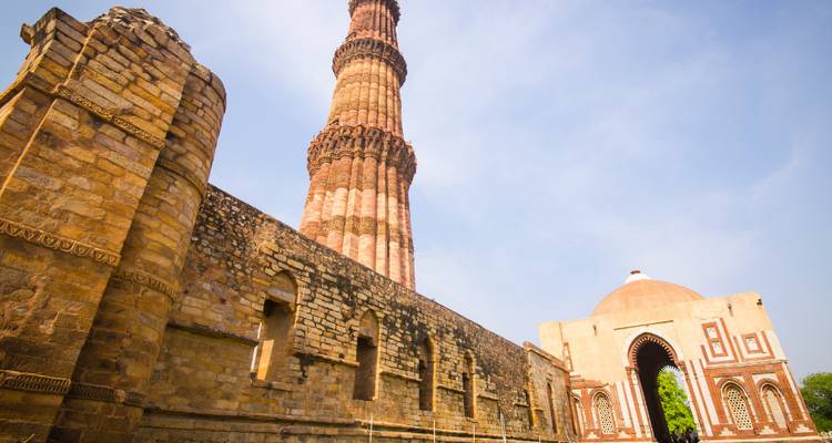 Qutub Minar met ingewikkelde gravures en koepelstructuren.