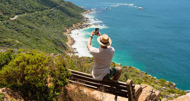 Persona tomando una foto de acantilados costeros pintorescos.
