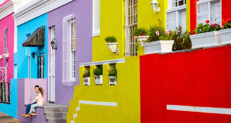 Casas coloridas con una persona sentada en los escalones.