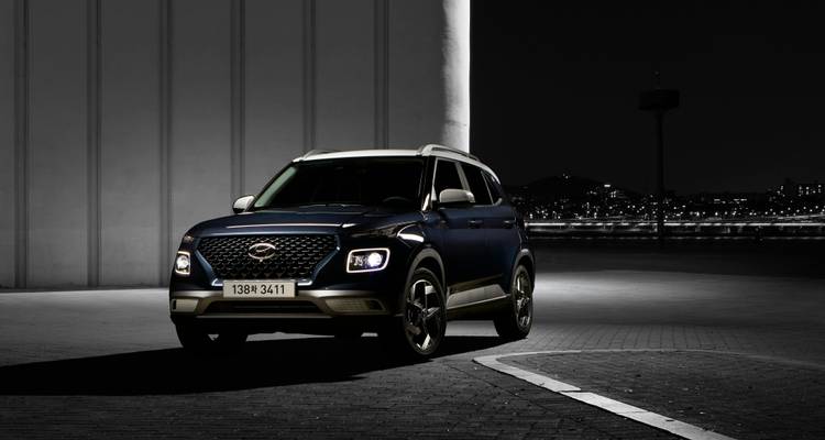 Dark blue car parked in an urban setting at night.