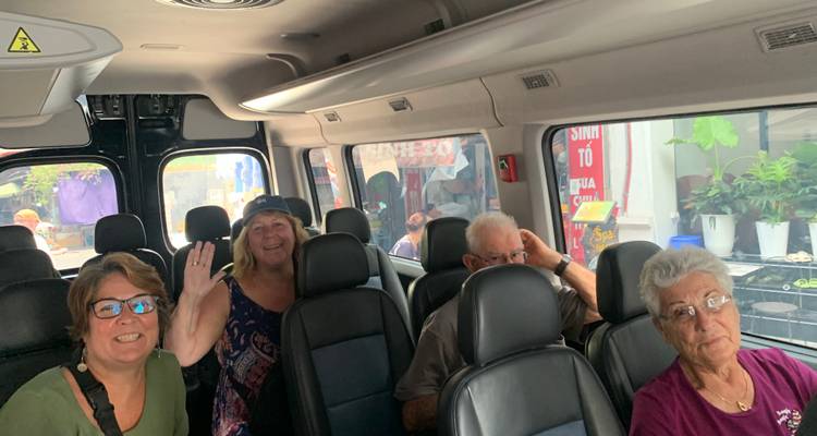 Group of people seated inside a vehicle.