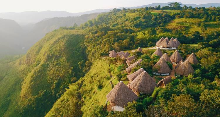 Scenic view of traditional huts on a hillside surrounded by green landscape.