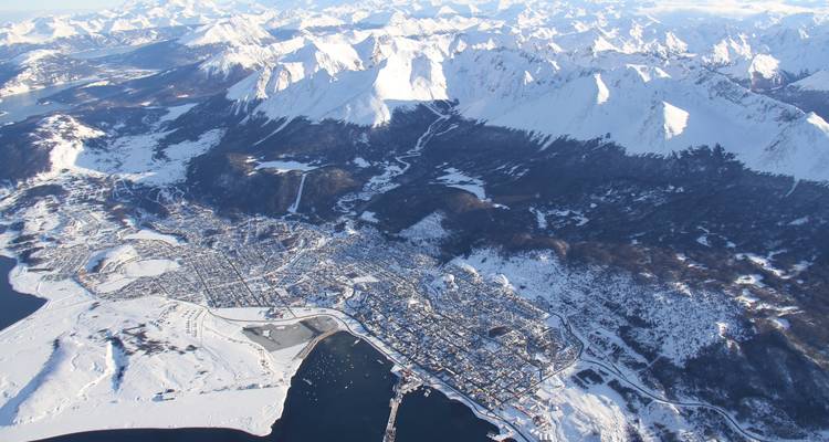 Vue aérienne d'Ushuaia enneigée et des montagnes environnantes.