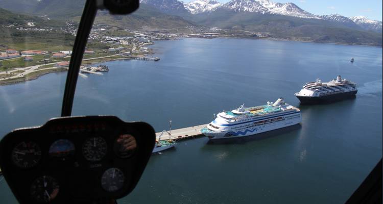 Vue aérienne d'une ville côtière avec des navires de croisière amarrés.
