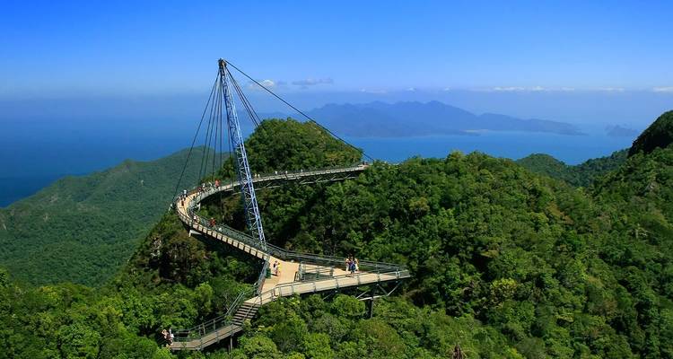 De Curving Langkawi Sky Bridge overspant met bomen bedekte bergen met de blauwe zee ver beneden