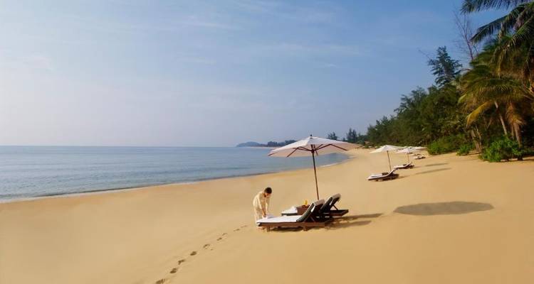 Plage déserte avec transats et parasols, avec une personne