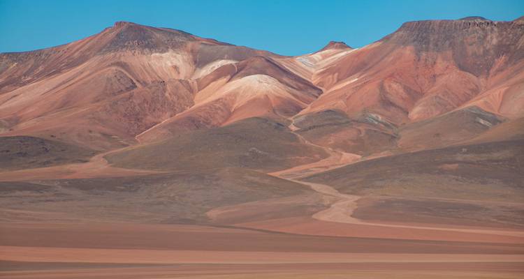 Montagnes colorées du désert sous un ciel dégagé.