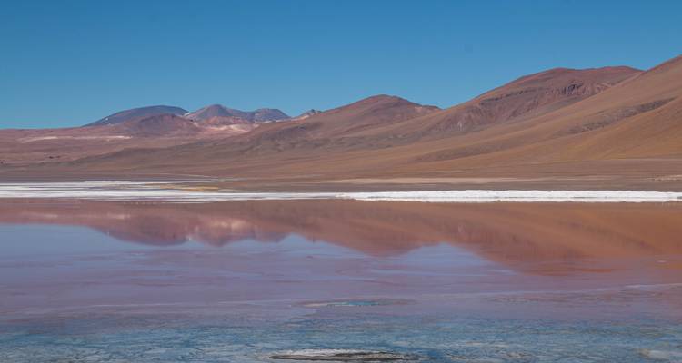 Reflet des montagnes dans un lagon coloré.