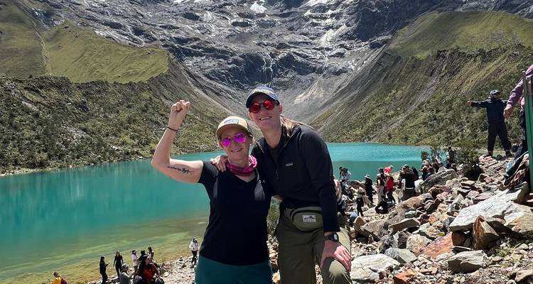 Deux randonneurs posant près d'un lac de montagne turquoise.