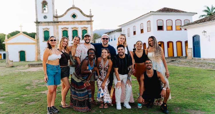 Grupo de personas posando felizmente frente a edificios históricos
