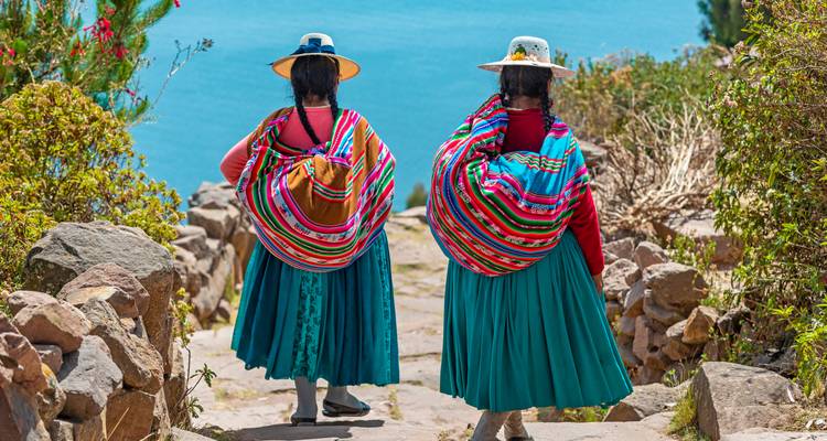 Dos mujeres con ropa tradicional caminando por un sendero