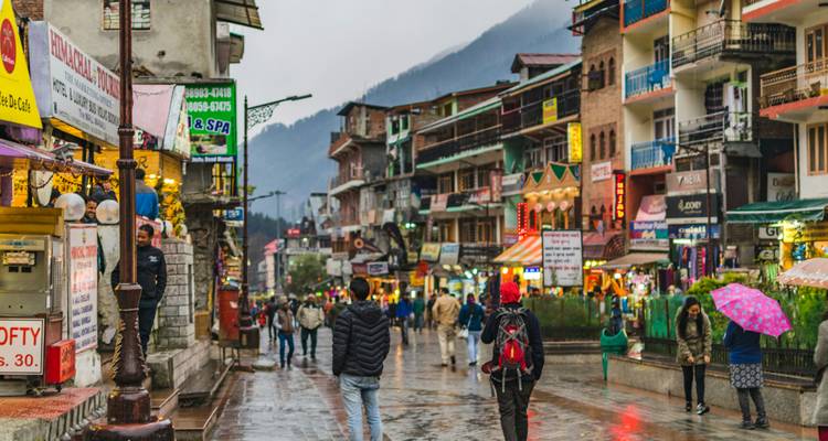 Rue animée dans une ville de montagne avec des gens et des magasins.