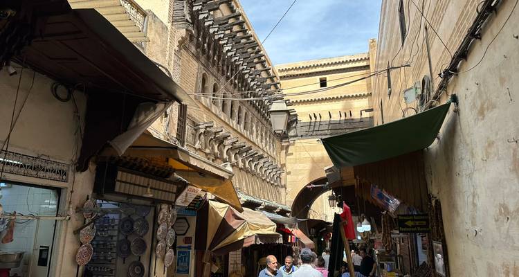 Rue historique à Fès avec des gens qui marchent.