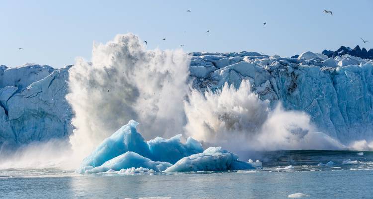 Vêlage glaciaire avec de la glace se brisant dans l'eau.