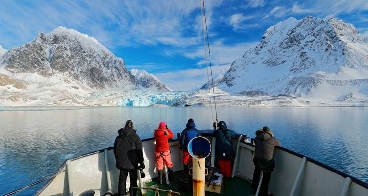 Des touristes sur un navire observant des montagnes glacées.