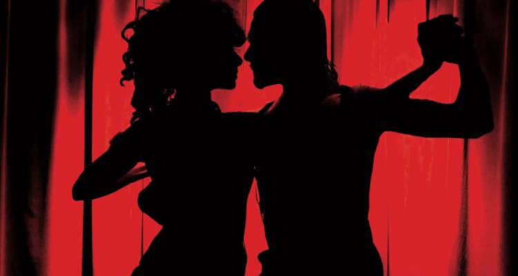 Silhouette de deux danseurs sur un fond rouge.