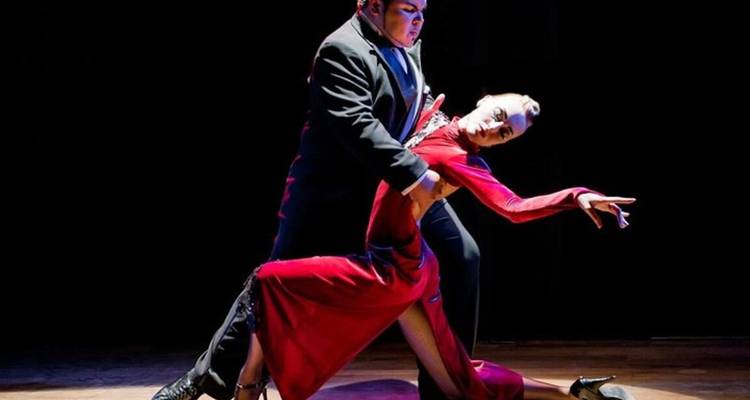 Danseurs de tango se produisant sur scène sous les projecteurs.