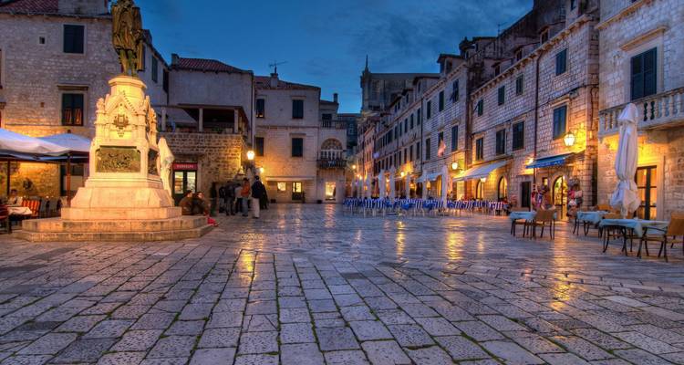 Avondgezicht op een plein met historische gebouwen.