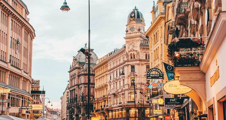 Belebte Stadtstraße mit historischer Architektur und verschiedenen Ladenschildern.
