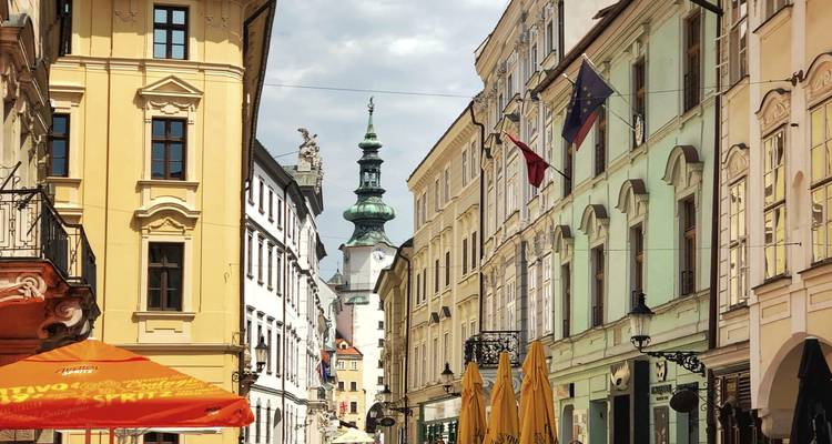 Schmale Straße mit bunten alten Gebäuden und einem Kirchturm.