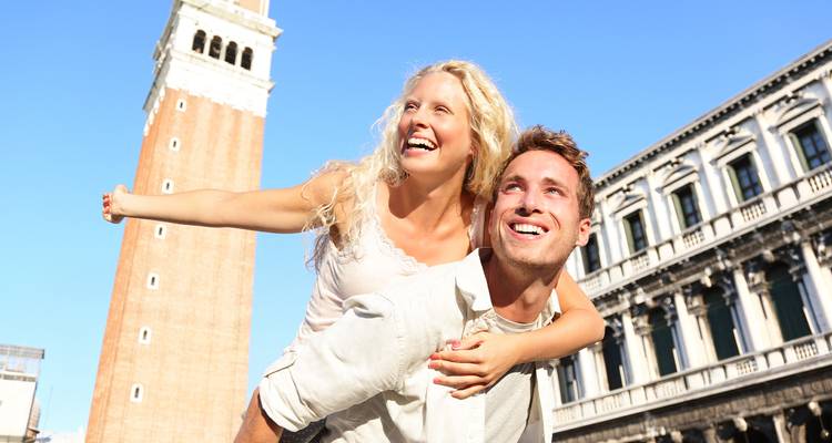 Couple heureux posant avec le Campanile de Saint-Marc de Venise en arrière-plan.
