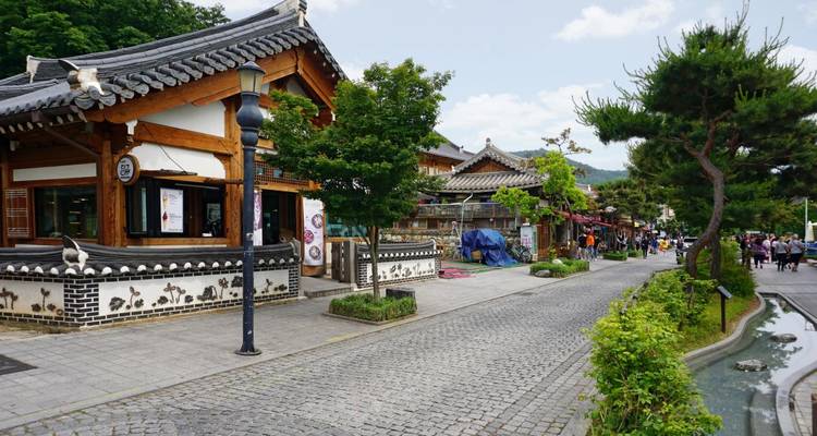 Charmante rue dans un village traditionnel coréen avec des arbres et des boutiques.