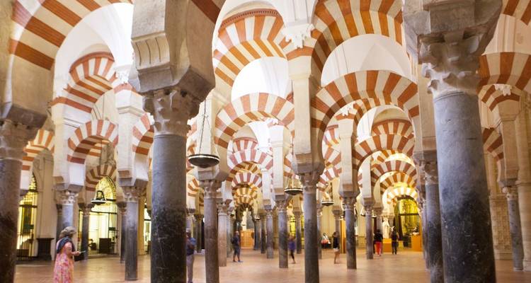 Das Innere einer historischen Moschee mit Bögen und Säulen.