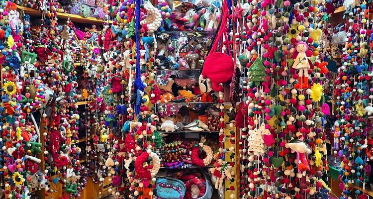 Levendige uitstalling van kleurrijke handgemaakte artikelen aan een marktkraam.