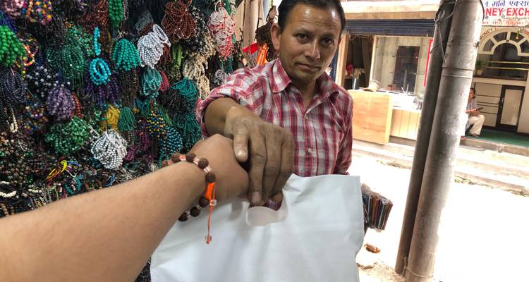 Persoon die een artikel koopt van een verkoper bij een marktkraam.