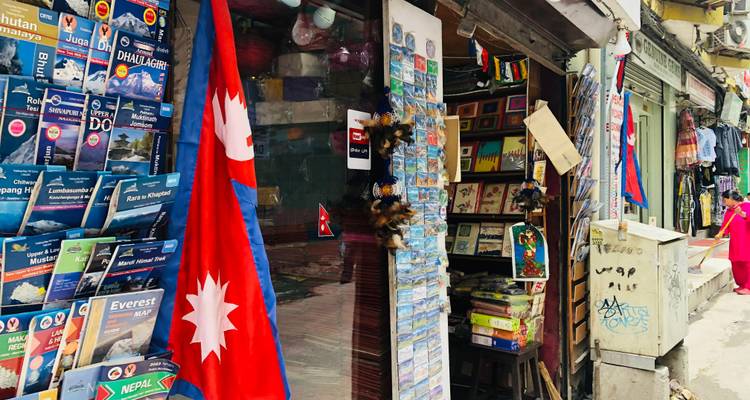 Een straatbeeld met vlaggen en winkelbordenin een commercieel gebied.