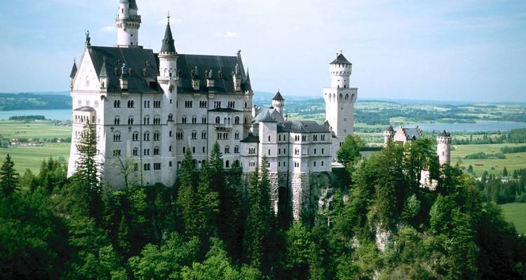 Vue d'un château entouré d'une végétation luxuriante.