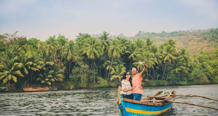 Couple on a boat enjoying a serene waterway with lush vegetation.