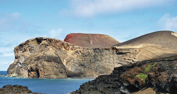 Zerklüftete, vulkanische Küstenlinie mit einer Felsklippe und blauem Ozean