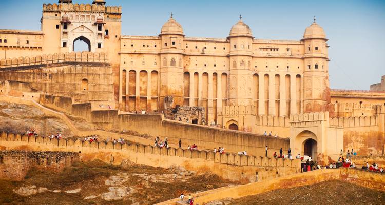Un grand fort avec des gens qui marchent le long des murs extérieurs.