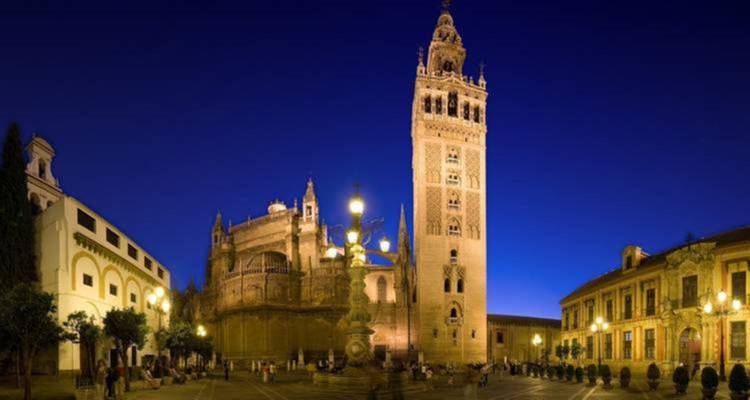 Kathedrale von Sevilla und Giralda-Turm nachts beleuchtet.