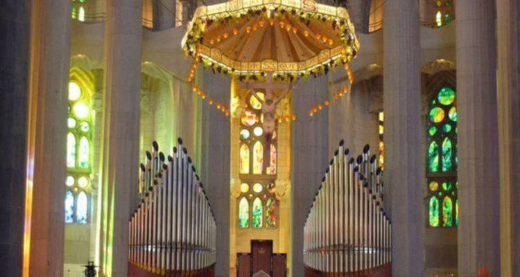 Inneres einer Kathedrale mit Buntglasfenstern und Orgelpfeifen.