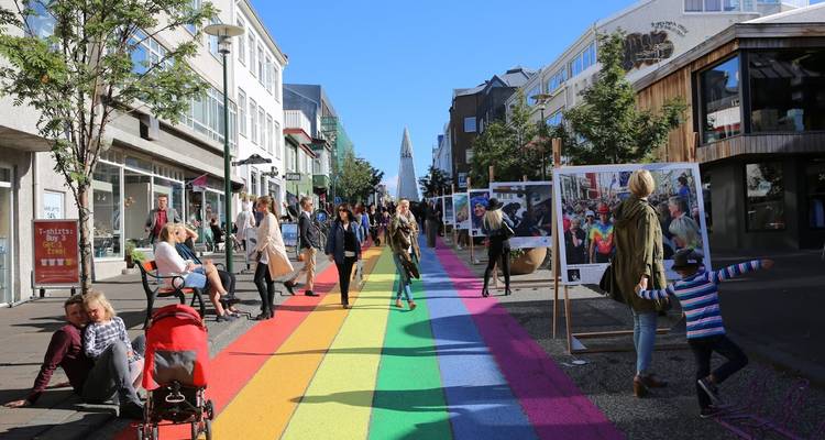 Des gens qui marchent dans une rue colorée avec des œuvres d'art.