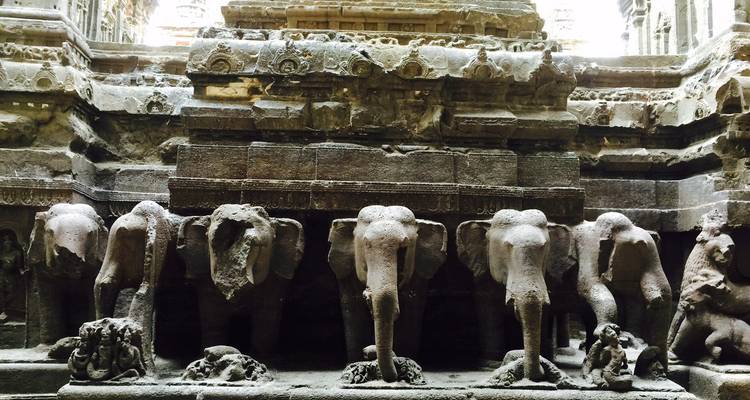 Sculptures d'éléphants en pierre alignées dans une structure ancienne.
