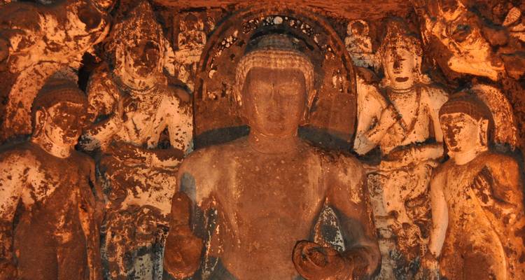 Une sculpture sur pierre détaillée de Bouddha entouré de disciples.