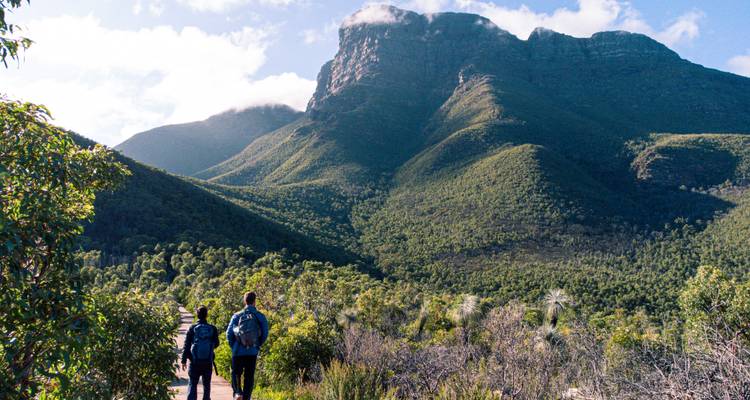 Hikers walking towards mountains