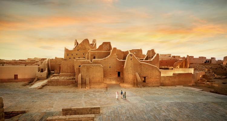 Oude ruïnes onder een zonsonderganghemel met een wandelend koppel.