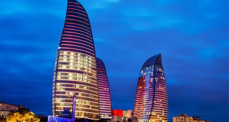 Tours de Flamme illuminées de bandes LED colorées dominant l'horizon de Bakou la nuit.