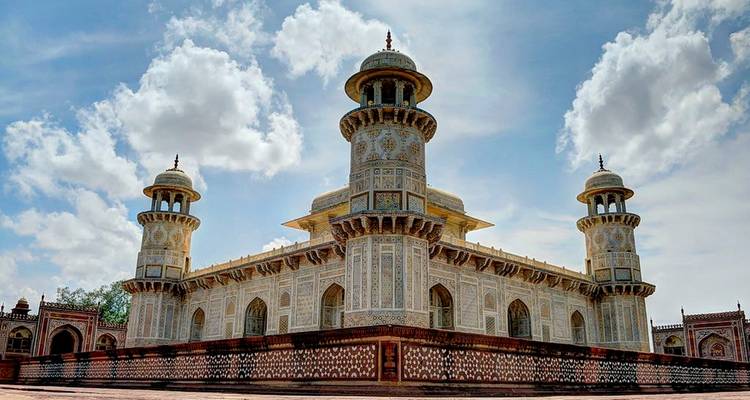 Bâtiment blanc finement décoré avec des dômes sur un ciel bleu.