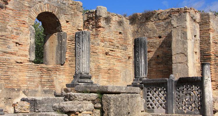 Ruines d'un ancien bâtiment en pierre avec des colonnes, probablement à Épidaure.